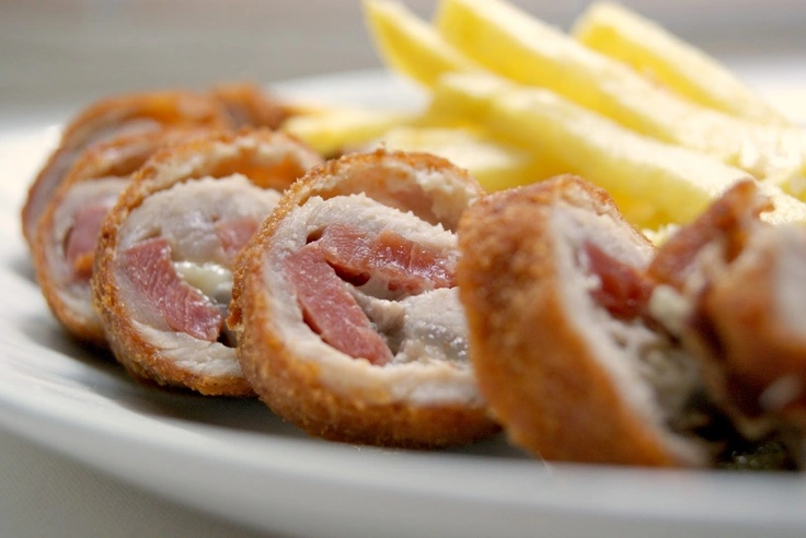 Flamenquín cordobés en rodajas con patatas fritas, tapa típica y tradicional en los bares de Córdoba.