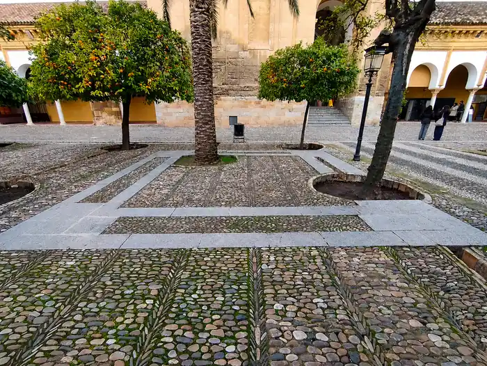Pavimento del Patio de los Naranjos de la Mezquita de Córdoba con los cimientos del primer alminar de Hisham I marcados en el suelo