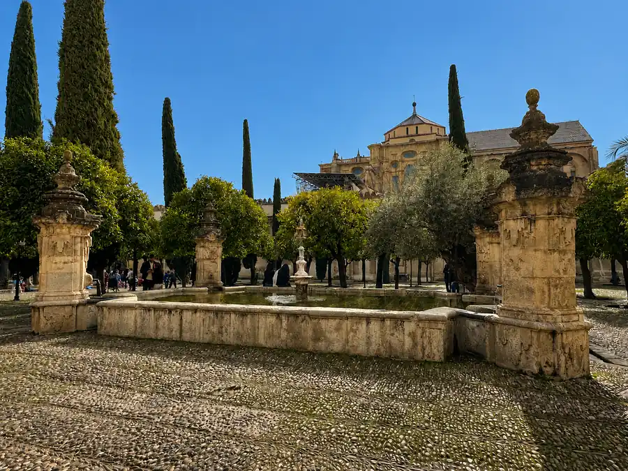 Fuente de Santa María en el Patio de los Naranjos de la Mezquita-Catedral de Córdoba, con su pilón rectangular de piedra negra y cuatro pilares