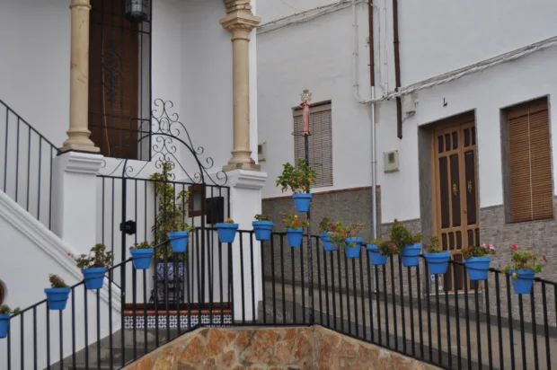 Calle encalada de Iznájar con macetas azules colgadas de la pared