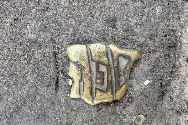 Placa de bronce incrustada en el pavimento empedrado que muestra el logotipo de la Red de Juderías de España, formando el mapa de la península con letras hebreas en relieve.